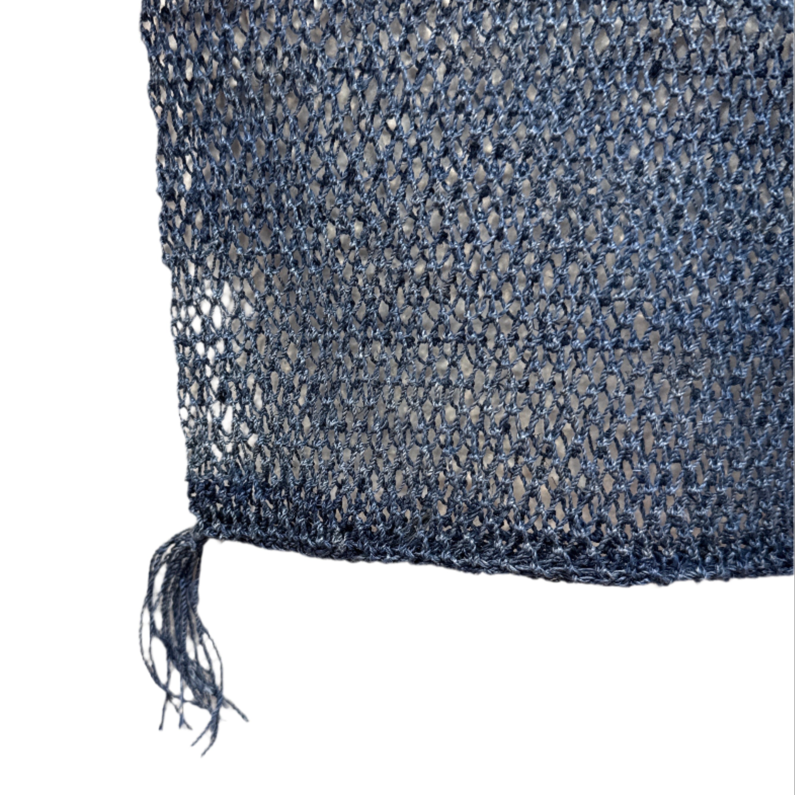 Close-up of blue fabric with a frayed edge on a white background