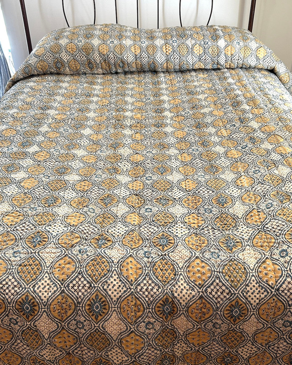 view 2 Handmade Natural Dyed Block Print Quilt Queen Bedspread India The design is block printed using several wooded blocks and dyed with natural dyes. Colors: mustard, charcoal and indigo blue on a cream background. 100% cotton. The back is a indigo blue color.