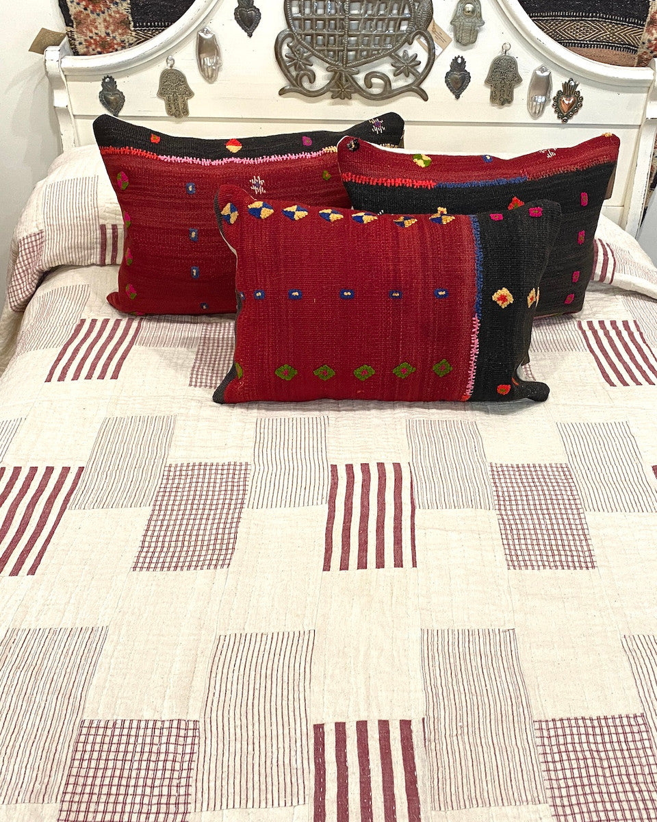 Handwoven Organic Cotton Patchwork Hand Stitched Queen Quilt India. his patchwork quilt has 4 different striped patterns in chalky red and natural white, and solid natural white blocks There are rows of white hand stitching one inch apart. The back is solid off-white natural cotton. It is two layers with a lightweight cotton batting inside.