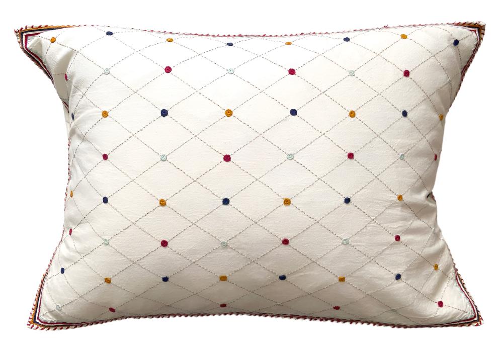 Hand Embroidered Cotton Mexico (14" x 20") The pillow is white with a grid of embroidered light grey lines. 1/4" circles in gold, red sea foam and navy. There is a narrow border embroidered around the pillow in these same colors. Tied back.