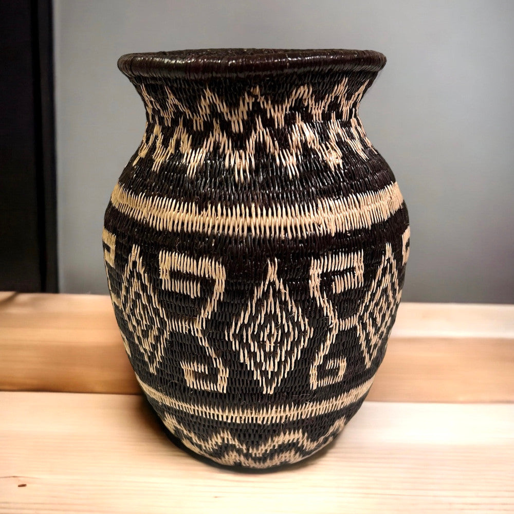 This small fine basket is made from natural palm fronds cut into fine strips. The sturdy basket is woven with a complex technique and with a fine tight pattern. The Wounaan women are considered the finest basket makers in the world. Through basketry they help preserve their culture and in so doing they respect the earth with sustainable harvesting practices. Colors: black, and wheat. 