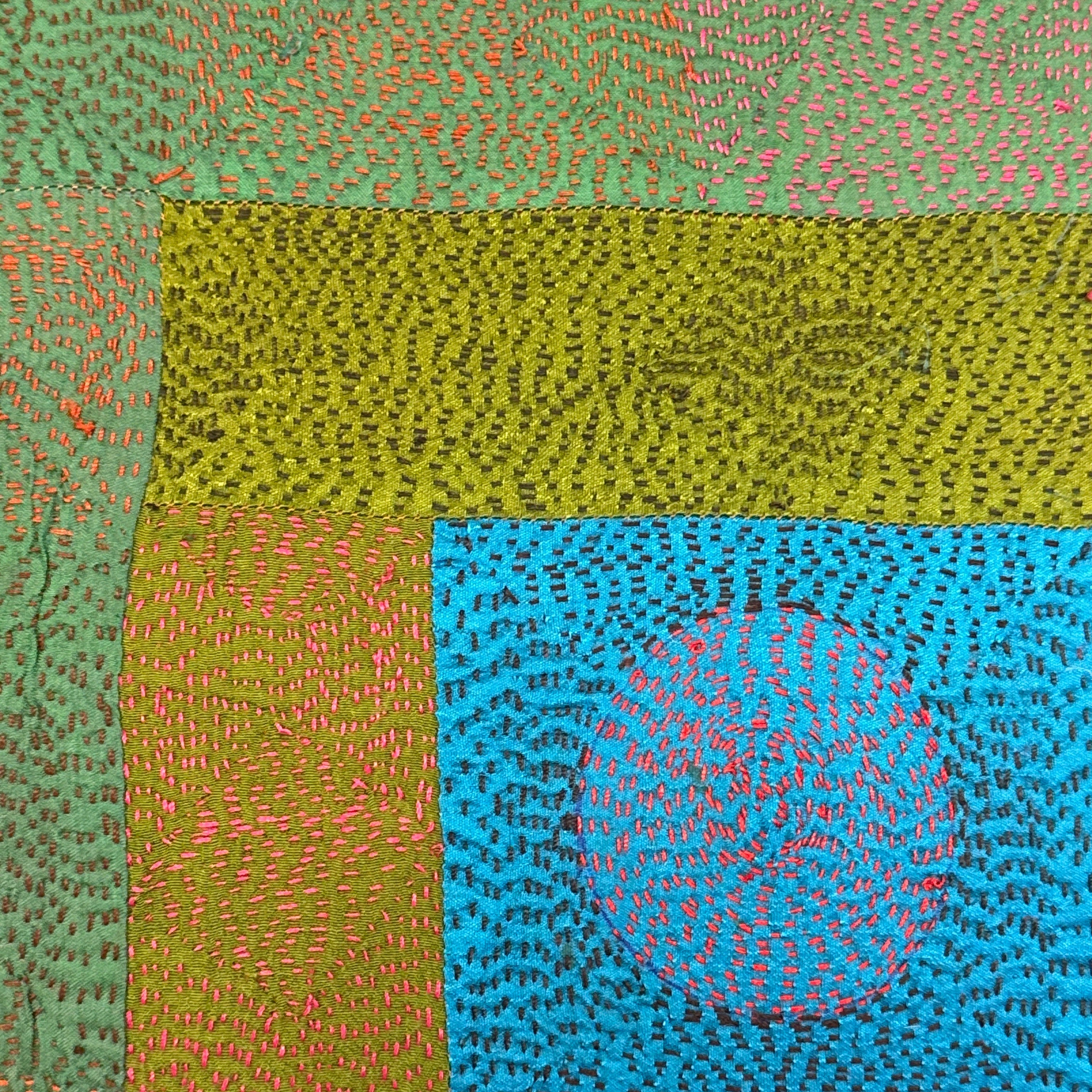 Textured fabric with a circular pattern in the center, surrounded by green and blue sections.