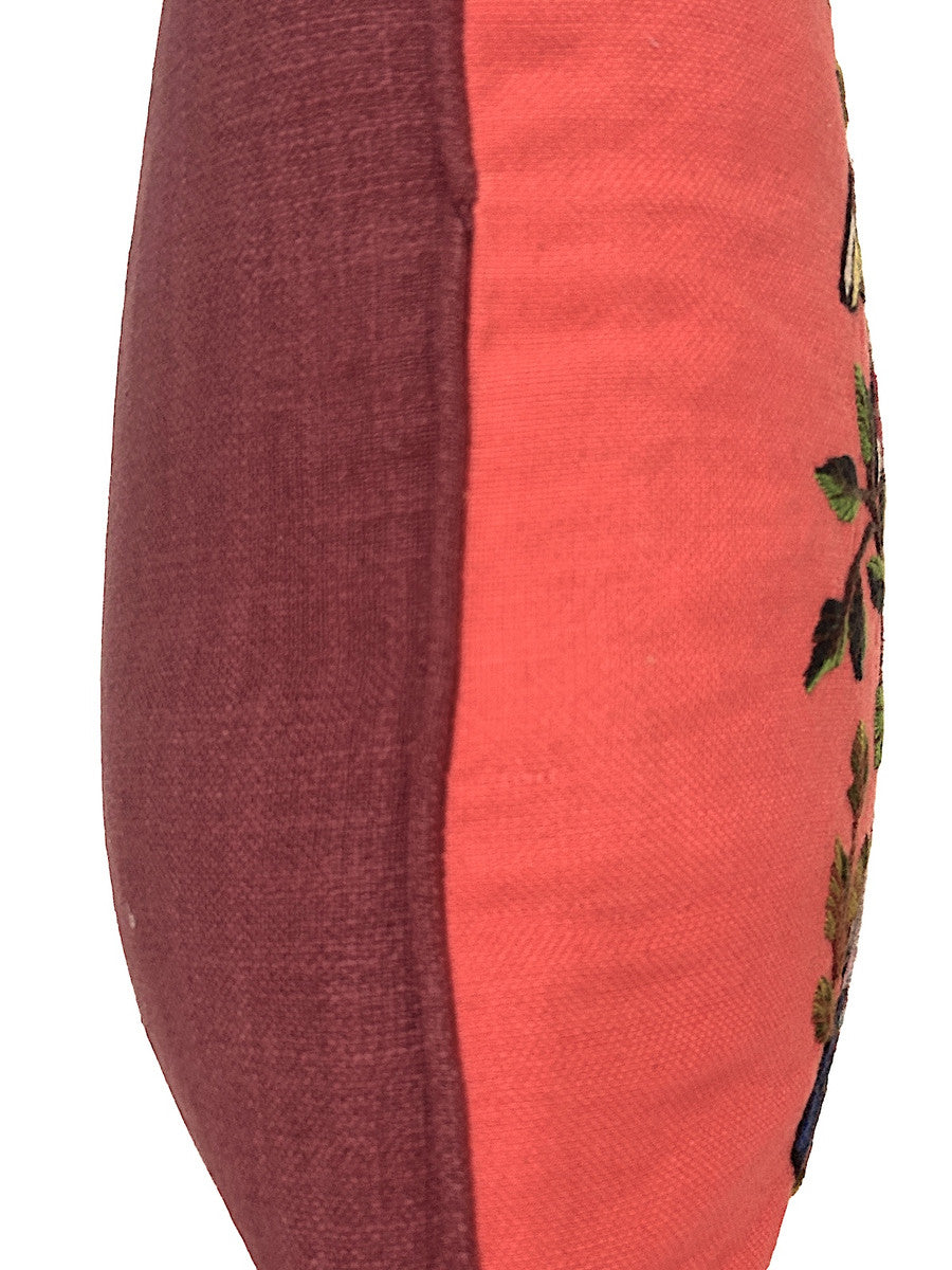 side view he pillow handwoven peachy pink colored cotton cloth.  Each bird is unique-so allow for some variations. The back and hand rolled piping are  a burgundy colored linen cloth. The birds are many bright colors with a black outline. The branches and leaves various greens and browns with some burgundy. Hidden zipper with 90-10 feather/down pillow insert.